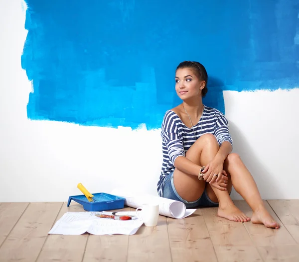 페인팅 후 벽 근처 바닥에 앉아있는 여성 화가의 초상화. — 스톡 사진