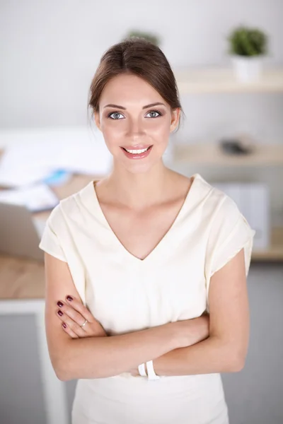 Attraente donna d'affari con le braccia incrociate in piedi in ufficio — Foto Stock