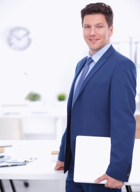 Ofiste masasının karşısında duran bir iş adamı ya da yönetici.