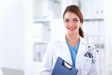 Hastanede üniformalı, gülümseyen bir kadın doktor.