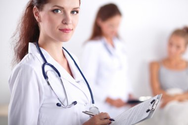 Hastanede üniformalı, gülümseyen bir kadın doktor.