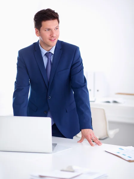 Uomo d'affari o manager in piedi contro la sua scrivania in ufficio — Foto Stock
