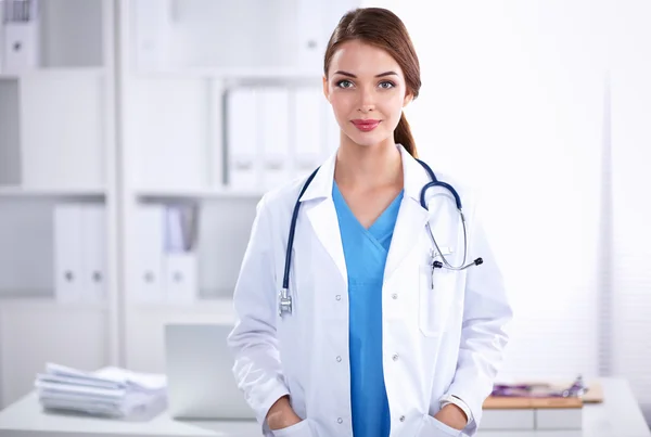 Portrait of young woman doctor with white coat standing in hospital — Stock Photo, Image