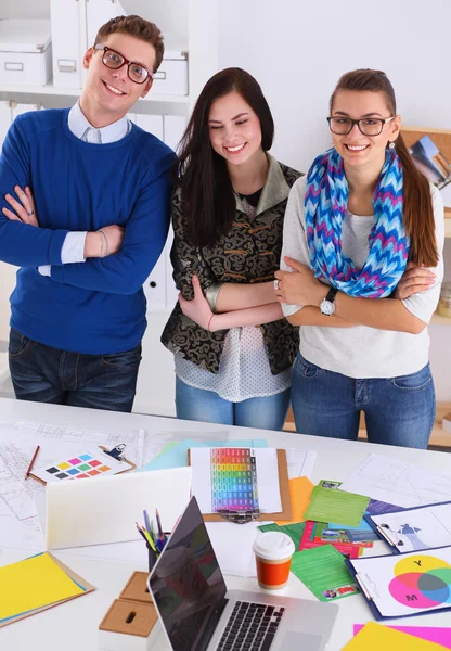 Junge Geschäftsleute stehen im Büro am Schreibtisch — Stockfoto