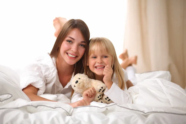 Femme et jeune fille couchée au lit souriant — Photo