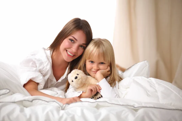 Donna e giovane ragazza sdraiata a letto sorridente — Foto Stock