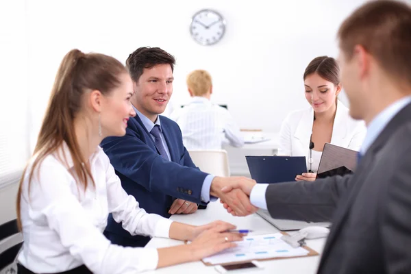 Empresários apertando as mãos, terminando uma reunião, no escritório — Fotografia de Stock