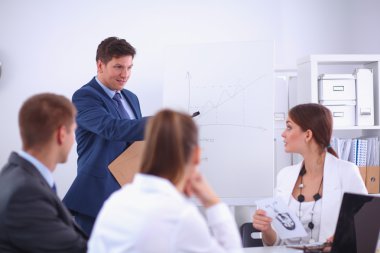 İş adamları iş toplantısında, ofiste oturup tartışıyorlar.