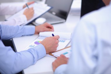 İş toplantılarında, ofiste oturan ve yazan iş adamları.
