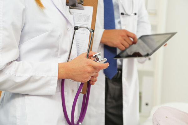 Doctor man showing something woman on tablet pc in hospital