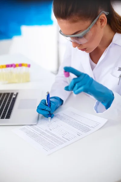 Vrouwelijke onderzoeker is omringd door medische flacons en flacons, geïsoleerd op witte achtergrond — Stockfoto