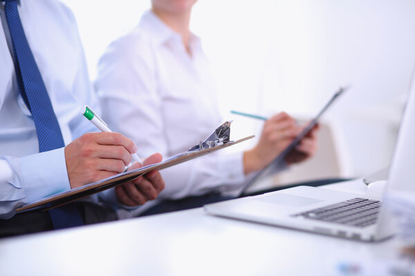 Business people sitting and writting at business meeting, in office