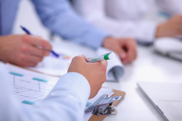 Zakenmensen zitten en schrijven op zakelijke bijeenkomst, in functie — Stockfoto