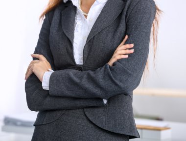 Ofiste kollarını kavuşturmuş duran iş kadını portresi.