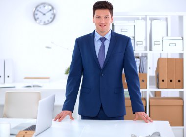 Kendine güvenen başarılı genç işadamı eğilimli silah masasının üzerindeki