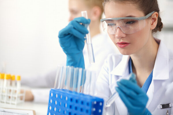 Woman researcher is surrounded by medical vials and flasks, isolated on white background