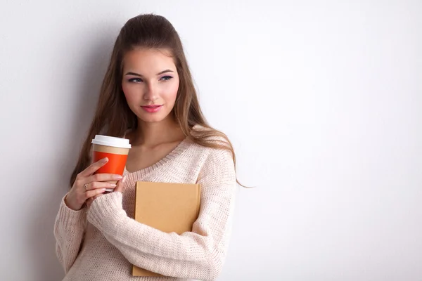 Portrait d'une jeune femme avec une tasse de thé ou de café, tenant un livre — Photo