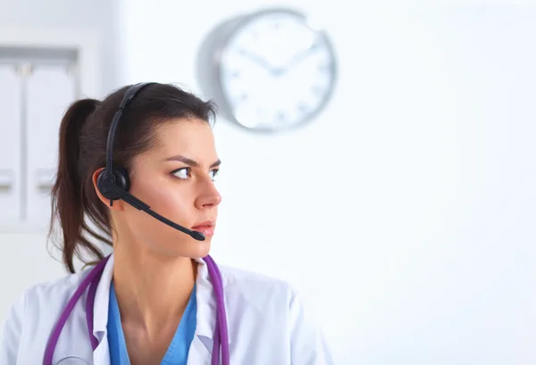 Dokter draagt een headset zittend achter een bureau met laptop — Stockfoto