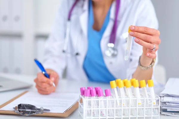 Woman researcher is surrounded by medical vials and flasks, isolated on white background — Stock Photo, Image