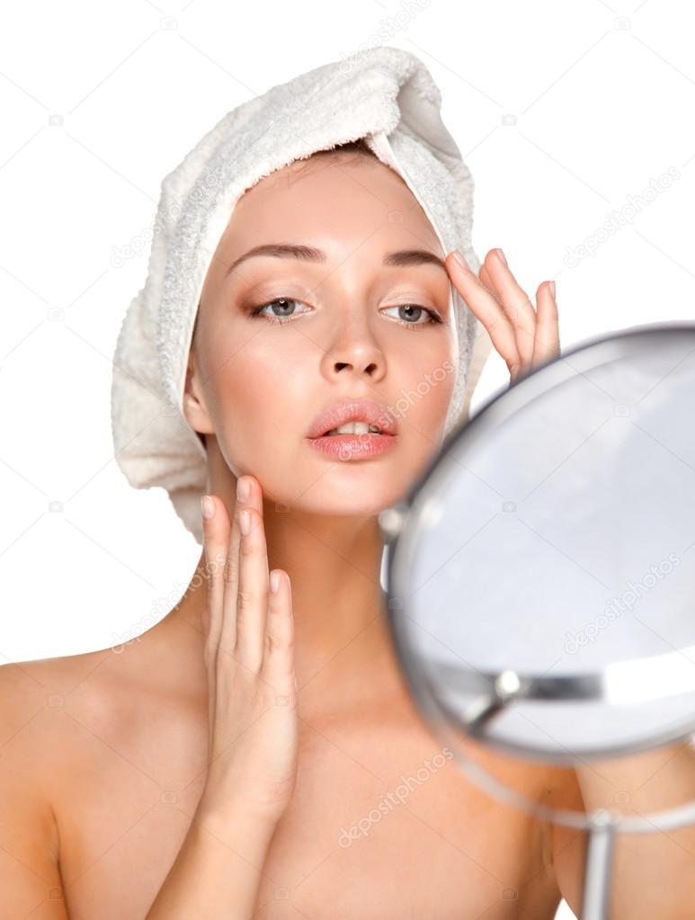 Portrait of beautiful girl touching her face with a towel on  head