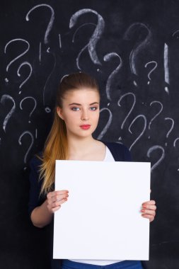 soru işareti gri arka plan üzerinde boş bir holding ile genç kız