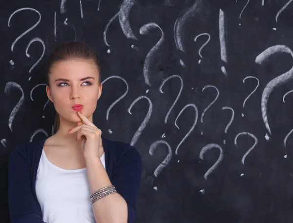 Young girl with question mark on a gray background — Stock Photo, Image