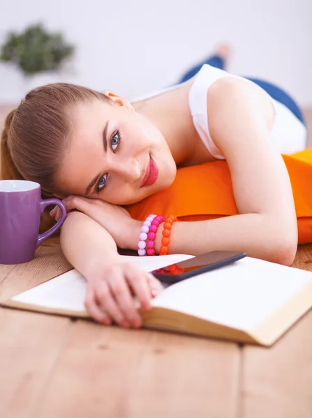 Mujer joven sonriente acostada en un suelo blanco con almohada — Foto de Stock