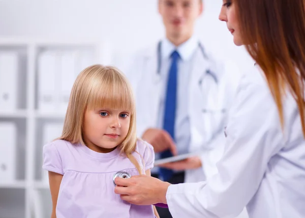 Médico femenino examinando a un niño con estetoscopio en cirugía — Foto de Stock