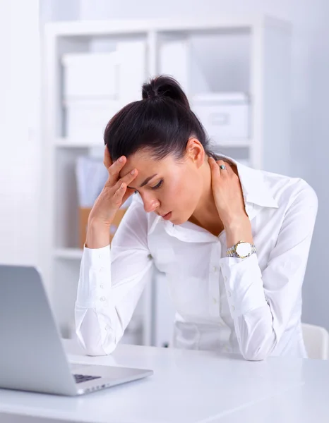 Empresária stressada sentada à secretária no escritório — Fotografia de Stock