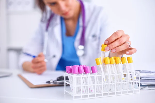 Kvinnlig forskare är omgiven av medicinska flaskor och kolvar, isolerade på vit bakgrund — Stockfoto
