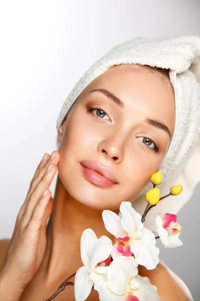 Woman in towel with orchid flowers — Stock Photo, Image