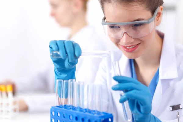 Woman researcher is surrounded by medical vials and flasks, isolated on white background — Stock Photo, Image