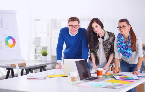 Young business people standing at office near desk — Stock Photo, Image