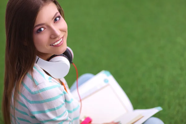 Femme livre de lecture se trouve sur l'herbe verte — Photo