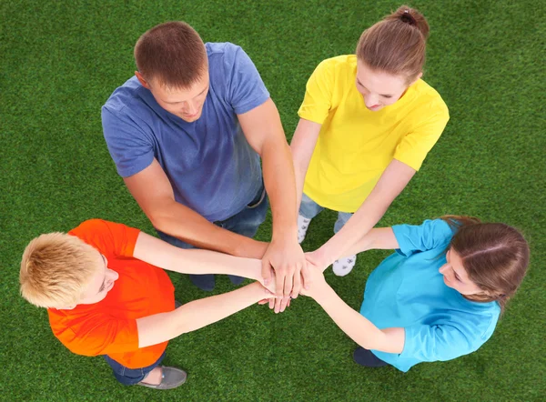 People joining their hands  on green grass — Stock Photo, Image