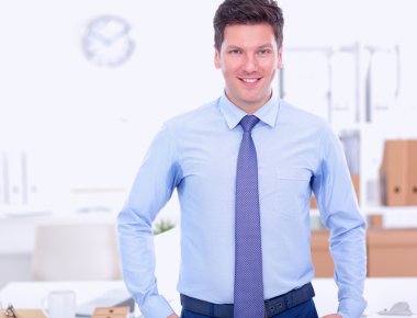 Ofiste masasının karşısında duran bir iş adamı ya da yönetici.