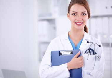Hastanede üniformalı, gülümseyen bir kadın doktor.