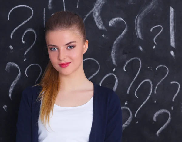 Junges Mädchen mit Fragezeichen auf grauem Hintergrund — Stockfoto