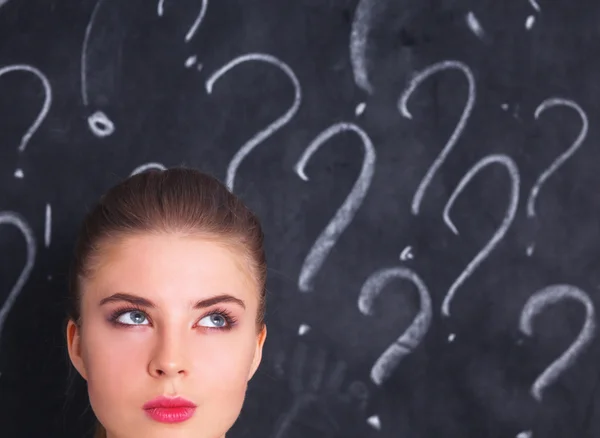 Young girl with question mark on a gray background — Stock Photo, Image