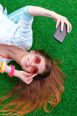 güzel ve genç birbayan yeşil çim yalan onu telefonla selfie yapma