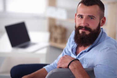 Genç işadamı koltukta oturuyor.