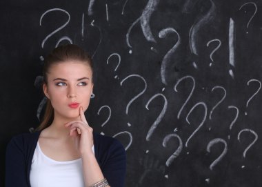 soru işareti gri bir arka plan üzerinde bulunan genç kız