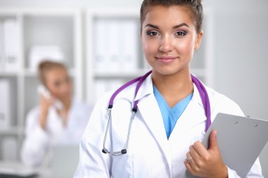 Hastanede üniformalı, gülümseyen bir kadın doktor.