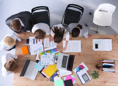 İş adamları iş toplantısında, ofiste oturup tartışıyorlar.