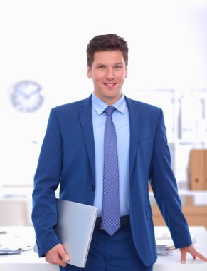 Ofiste masasının karşısında duran bir iş adamı ya da yönetici.