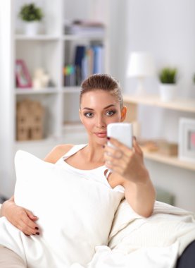 Yatak odasında cep telefonu ile kendini bir fotoğraf çekici mutlu esmer