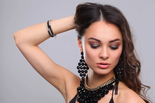 Retrato de una hermosa mujer con collar, aislado sobre fondo gris — Foto de Stock