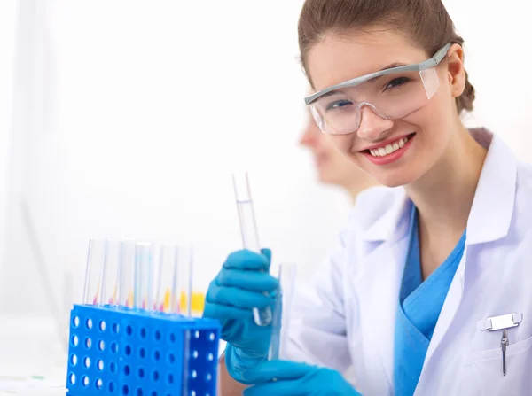 Woman researcher is surrounded by medical vials and flasks, isolated on white background — Stock Photo, Image