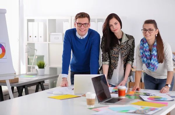 Young business people standing at office near desk — Stock Photo, Image