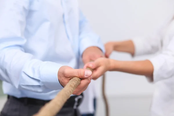 Konzeptbild eines Geschäftsteams, das ein Seil als Element der Teamarbeit im Vordergrund verwendet — Stockfoto